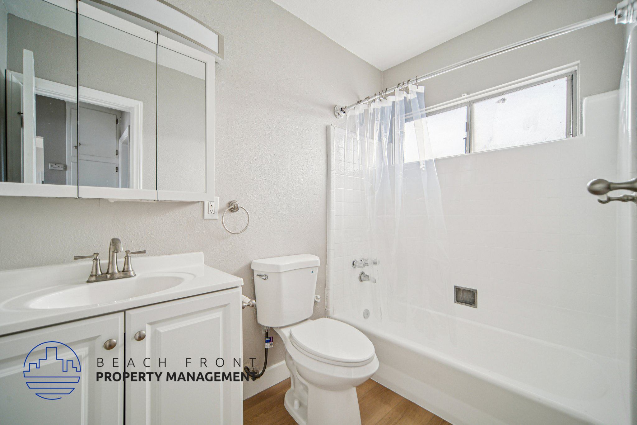 A white bathroom with a toilet, sink, and bathtub.